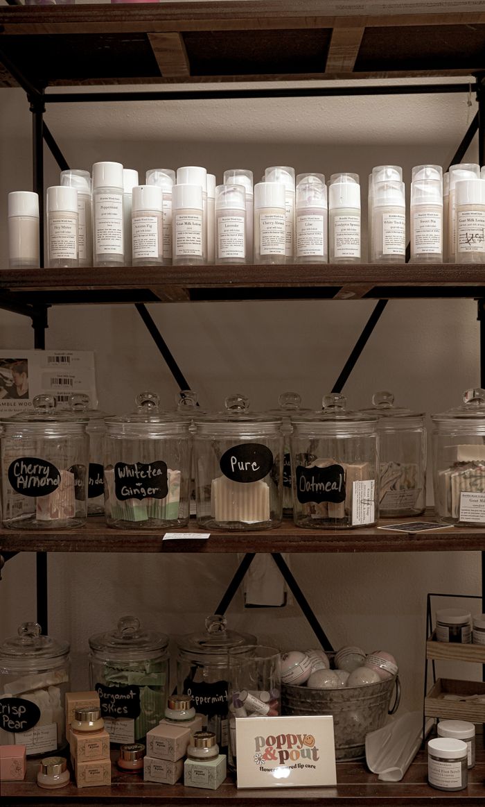 A variety of beauty products neatly arranged on wooden shelves in a cozy indoor setting.