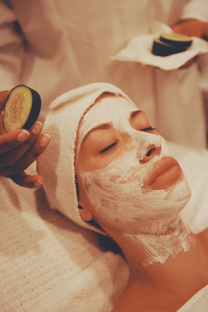 A woman receiving a rejuvenating facial mask at a spa, surrounded by soothing ambiance.