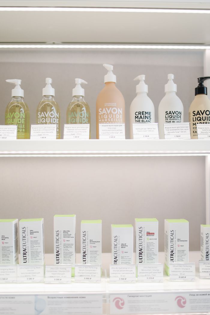 Elegant display of skincare products with bottles and boxes on illuminated shelves.
